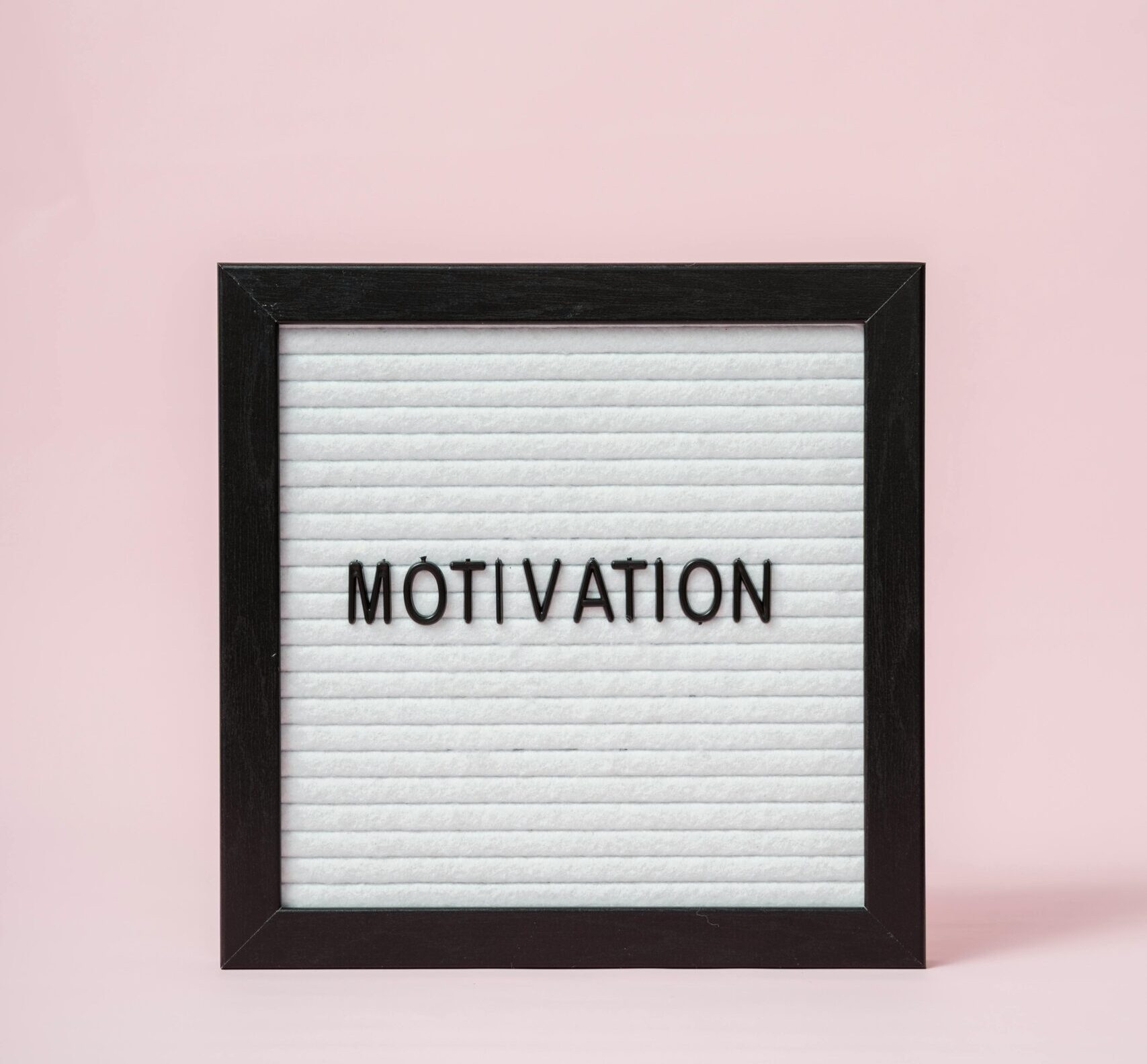 A letter board with 'Motivation' text on a soft pink background, perfect for inspirational themes.